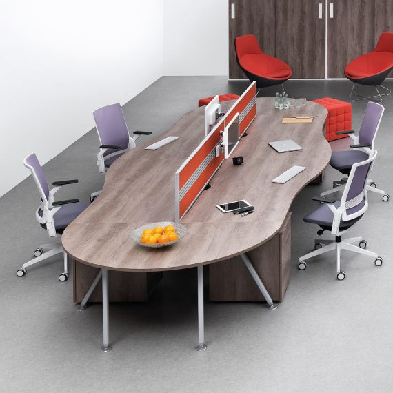 Wavy long desk in an office with four chairs, showing how to make hot desking work